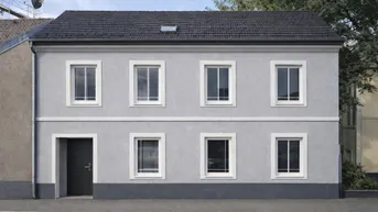 Gut erhaltenes Gebäude mit frisch renovierter grauer Fassade, weißen Fenstern und Satteldach.