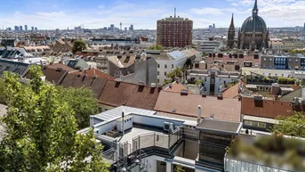 Panoramablick über die Dächer der Stadt mit markanten Gebäuden und grünen Bäumen im Vordergrund.