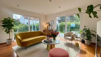 Virtuell eingerichtetes, helles Wohnzimmer mit großen Fenstern, Parkettboden und Zugang zum Garten.