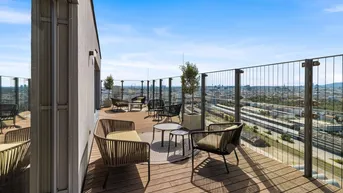 Weitläufige Dachterrasse mit Holzboden, Sitzgelegenheiten und Panoramablick über die Stadt.