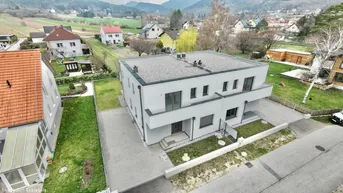 Modernes Doppelhaus mit Flachdach in ländlicher Umgebung mit Bergblick.