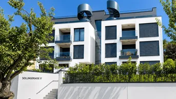 Modernes Mehrfamilienhaus mit weißer Fassade, Balkonen und begrüntem Vorgarten in sonniger Lage.