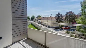 Heller Balkon mit Blick auf die Straße und umliegende Häuser, ideal für entspannte Stunden im Freien.