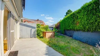 Gepflasterte Terrasse mit Zugang zum Garten und einer hohen Hecke für Privatsphäre.