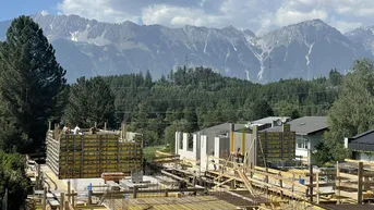 Baustelle für neue Gebäude mit Blick auf die majestätischen Berge und umliegende Naturlandschaft.