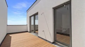 Große Dachterrasse mit Holzdielenboden und weitem Blick über die grüne Umgebung.