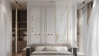 Modernes Schlafzimmer mit eleganter Marmor-Akzentwand, beigem Bett und stilvoller Beleuchtung.