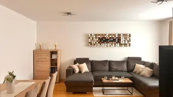 Geräumiger Wohn-Essbereich mit bequemer Eckcouch, Holzboden und modernem Wandbild.