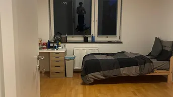 Helles Schlafzimmer mit Holzboden, Fenster und einem Bett mit Nachttisch.