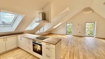 Moderne offene Küche mit Kochinsel, Dachschrägen und vielen Dachfenstern in einem hellen Raum.