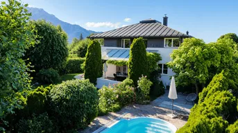 Idyllisches Anwesen mit großem Garten, Pool und atemberaubendem Bergblick unter strahlend blauem Himmel.