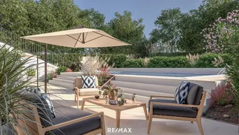 Moderne Terrasse mit bequemen Lounge-Möbeln, Sonnenschirm und Blick auf den Poolbereich.