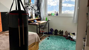 Kinderzimmer mit Schreibtisch, Holzfußboden und einem Boxsack, bietet einen weiten Blick auf die Berge.