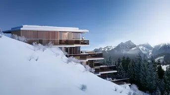 Moderne Architektur in den Bergen mit großen Glasfronten und Terrassen, umgeben von Schnee.