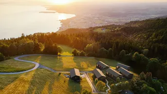 Spektakuläre Luftaufnahme der Häuser und des Sees bei Sonnenuntergang mit goldenem Licht.