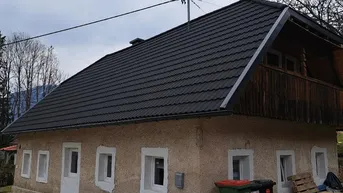 Traditionelles Haus mit Satteldach und gepflegter Fassade in ländlicher Umgebung.