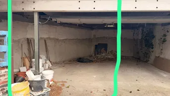 Unfertige Tiefgarage mit Betonboden und sichtbaren Holzträgern, bereit für den Ausbau.