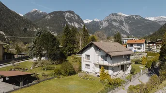 Idyllisches Einfamilienhaus mit großem Garten und Bergblick in ländlicher Umgebung.