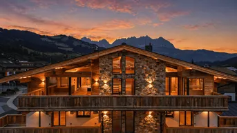 Beeindruckendes Chalet im alpinen Stil bei Sonnenuntergang mit beleuchteter Fassade und Bergblick.
