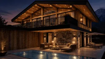 Moderne Villa im Chalet-Stil mit beleuchtetem Pool, gemütlicher Terrasse und Bergblick bei Dämmerung.