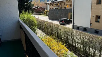 Balkon mit Blick auf die umliegende Berglandschaft und die darunterliegende Straße.