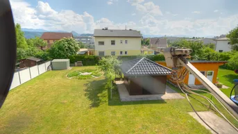 Großer, gepflegter Garten mit Rasenfläche, Gartenhaus und Bergblick in ruhiger Lage.