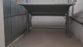 Tiefgaragenstellplatz mit einem mechanischen Parksystem für zwei Fahrzeuge in einem gepflegten Zustand.