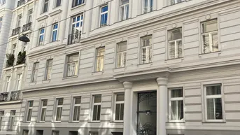 Elegante Fassade eines klassischen Wiener Wohnhauses mit vielen Fenstern und Balkonen in urbaner Umgebung.