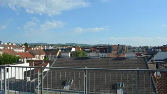 Panoramablick über die Dächer der Stadt mit weitem Horizont und blauem Himmel.