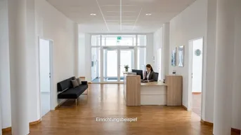 Geräumiger Empfangsbereich mit Rezeptionstresen, Sitzgelegenheit und hellem Holzfußboden in einem modernen Gebäude.