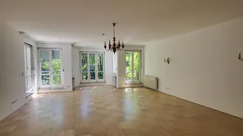 Helles, geräumiges Wohnzimmer mit Parkettboden und Zugang zu mehreren Fenstertüren.