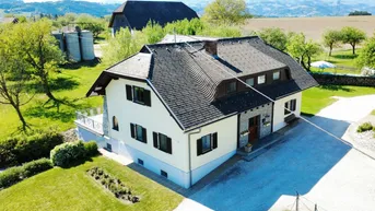 Freistehendes Haus mit komplexem Dach und weitläufigem Grundstück in ländlicher Umgebung mit Bergblick.