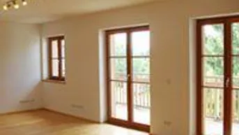 Helles Wohnzimmer mit Holzboden und Zugang zu einem Balkon, ideal für natürliche Belichtung.