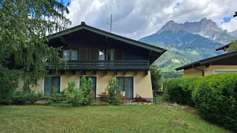 Traditionelles Haus im alpinen Stil mit Garten, Balkon und beeindruckendem Bergblick.