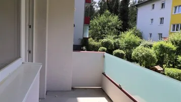 Geräumiger Balkon mit Glasbrüstung und Blick auf die Umgebung.