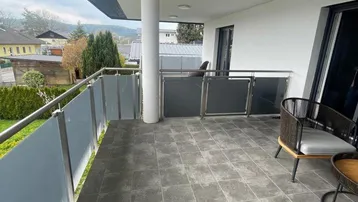 Geräumiger Balkon mit Fliesenboden, Sitzgelegenheiten und weitem Ausblick auf die Umgebung.