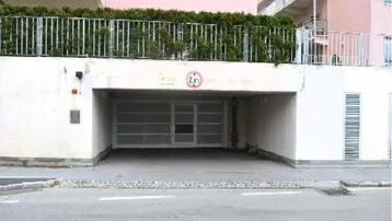Einfahrt zur Tiefgarage eines modernen Wohngebäudes mit Hecke und Höhenbegrenzung von 2,1 Metern.