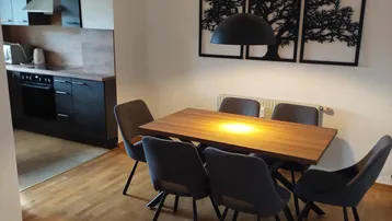 Moderner Essbereich mit Holztisch, bequemen Stühlen und offener Verbindung zur Küche.