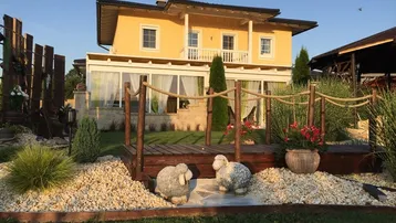 Gelbes Haus mit gepflegtem Garten, dekorativen Elementen und sonniger Atmosphäre.