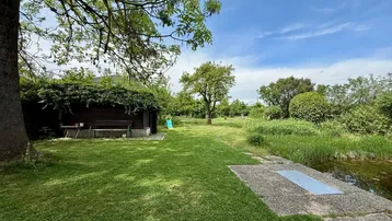 Großer, gepflegter Garten mit Teich, altem Baumbestand und Gartenhaus.