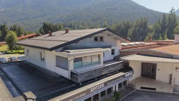 Gebäudeansicht mit moderner Architektur und Blick auf die umliegende Berglandschaft.