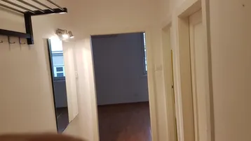 Heller Flur mit Spiegel und Garderobe, der zu weiteren Räumen führt.