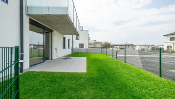 Gepflegte Rasenfläche und eine geflieste Terrasse bieten Platz für Erholung im Freien.