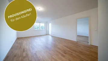 Helles, leeres Wohnzimmer mit Parkettboden und Zugang zu einem Balkon, bereit zum Einzug.