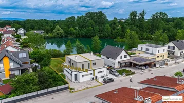 Luftaufnahme des Hauses mit markiertem Grundstück und Blick auf einen nahegelegenen See.