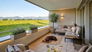 Geräumiger Balkon mit bequemen Loungemöbeln, Bergblick und einem entspannten Hund.