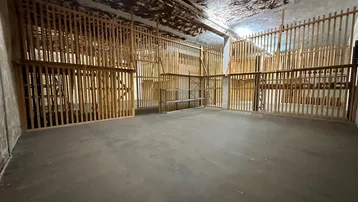 Großer Lagerraum mit Betonboden und Holzabtrennungen, ideal für verschiedene Lagerzwecke.