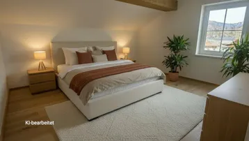 Gemütliches Schlafzimmer mit Holzbalken, schrägen Decken, Holzboden und Bergblick.