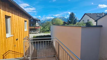 Panoramablick von der Außentreppe auf die umliegende Berglandschaft und benachbarte Häuser.