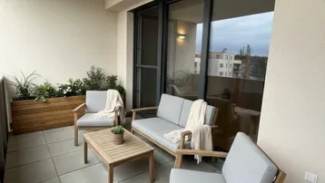 Gemütlicher Balkon mit modernen Outdoor-Möbeln und Fliesenboden, ideal zum Entspannen im Freien.